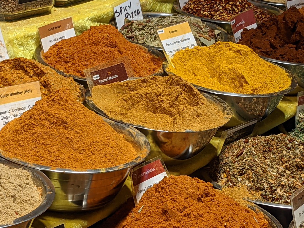 Bowls filled with colorful spices at a market stall.