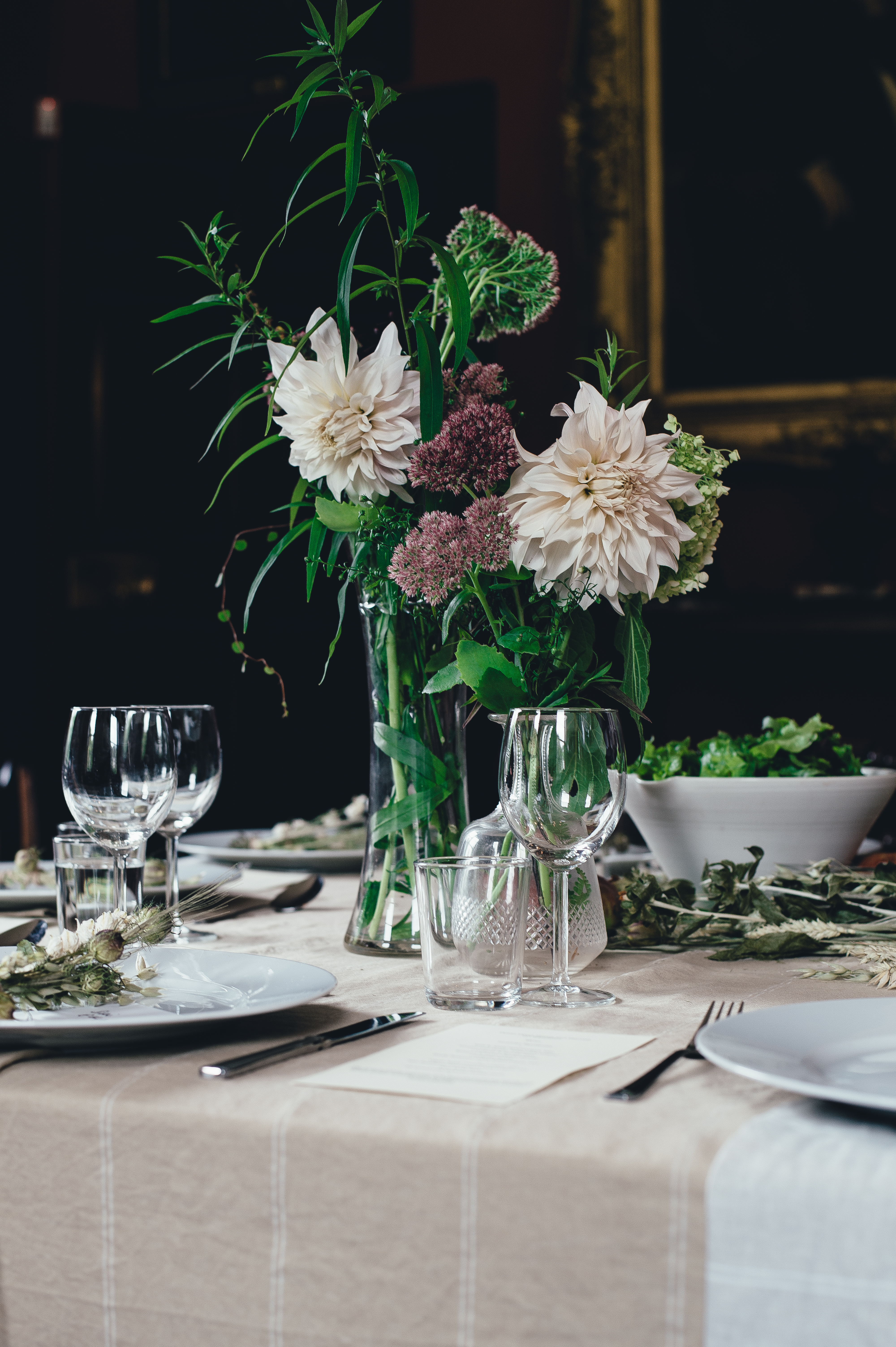 Elegant dinner table set with flowers, plates, glasses, and candles