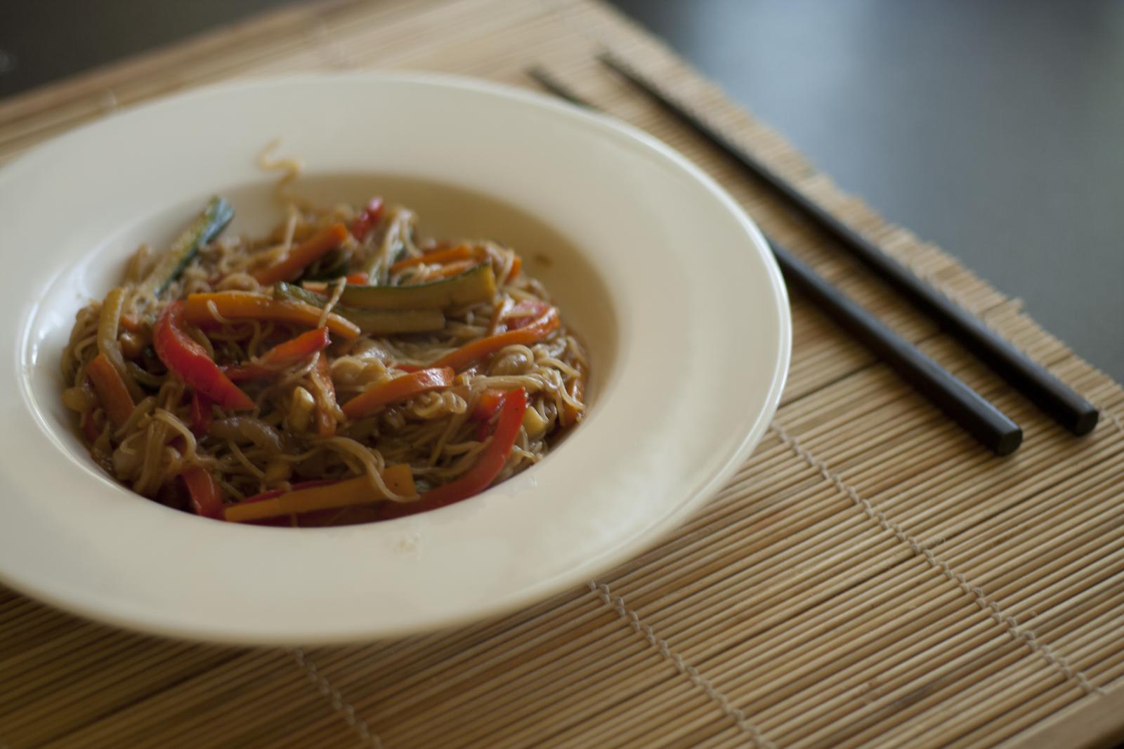 Bowl of rice noodles with vegetables and soy-based sauce