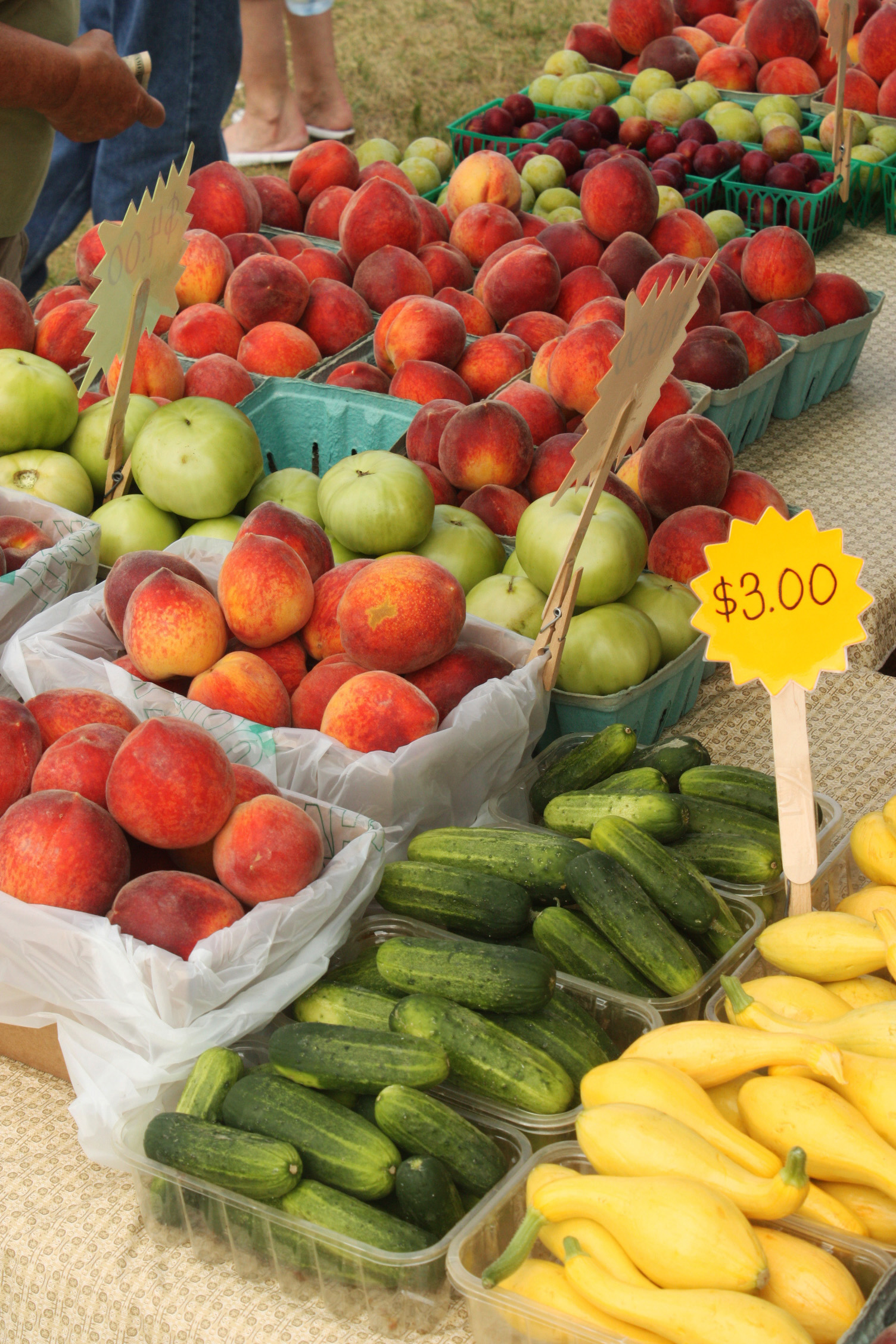 Seasonal fruits and vegetables displayed at a farmers market stall